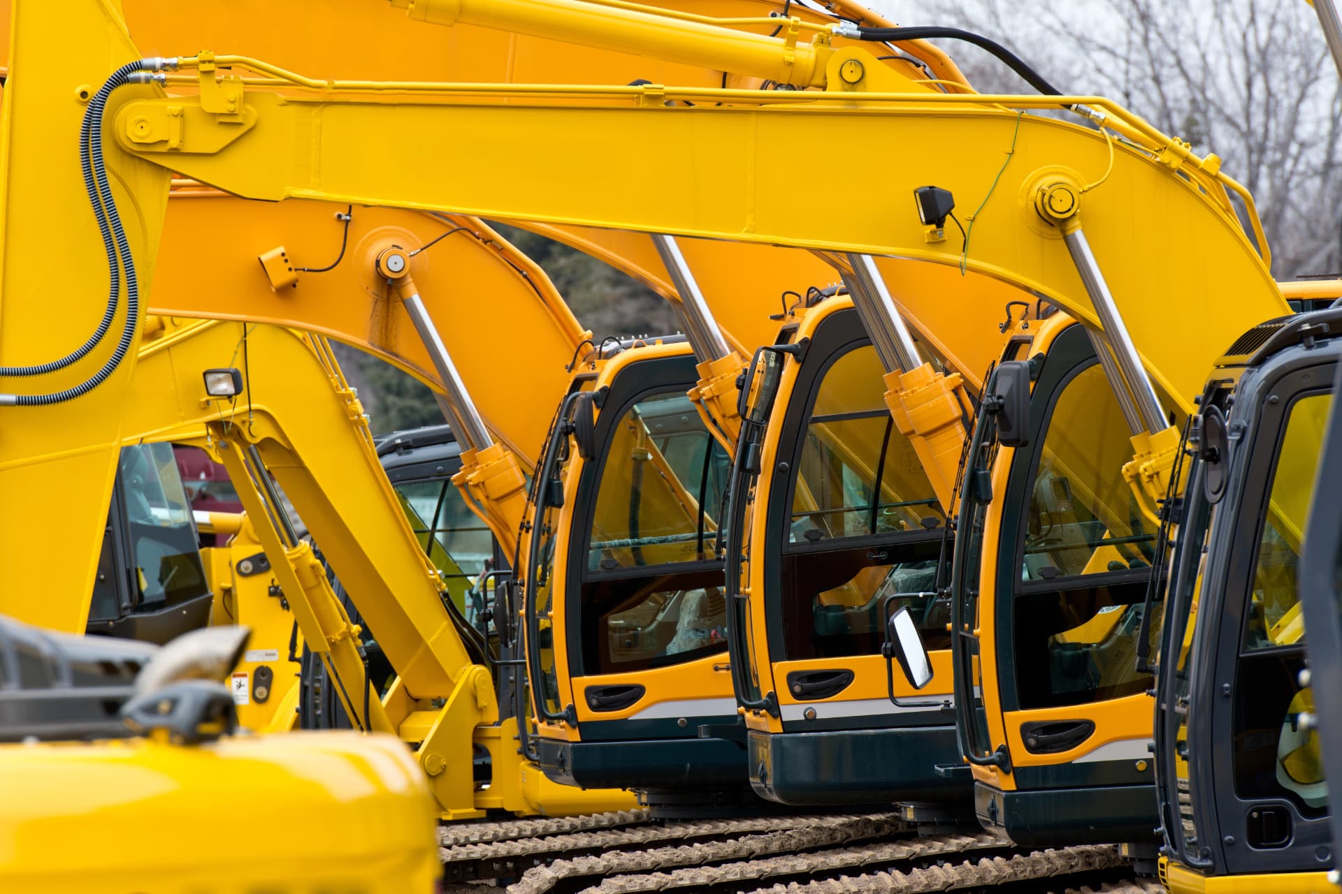 Row of yellow excavators on a heavy equipment dealer lot