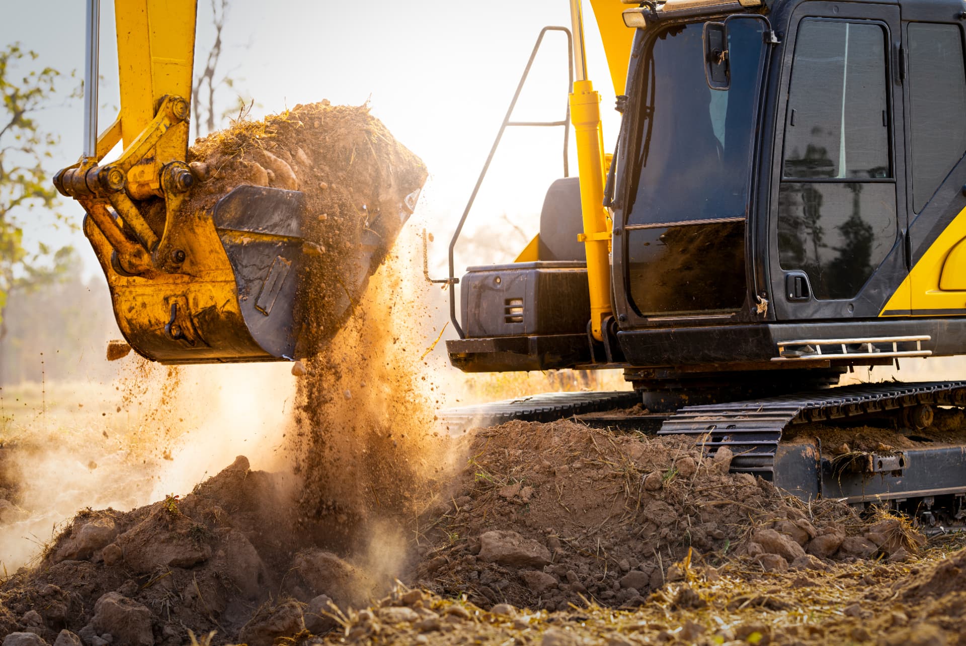 Excavator digging on a construction site at sunrise