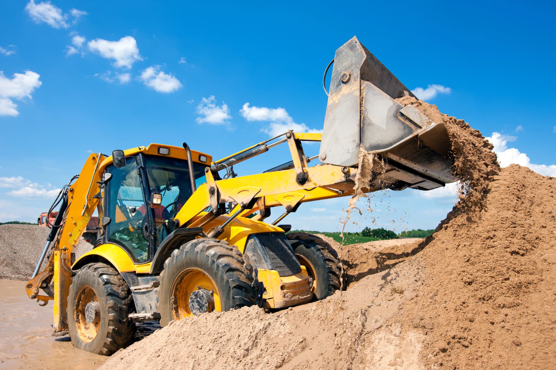 Backhoe loader serviced with a sealed RPM oil and fluid evacuation system